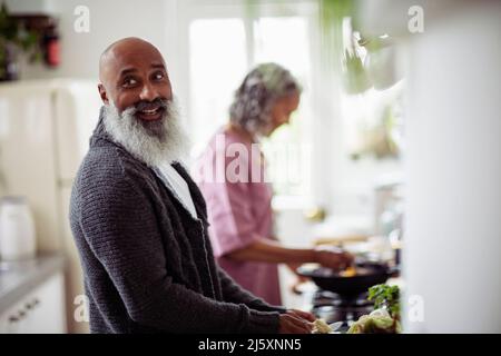 Glückliches Seniorenpaar, das in der Küche kocht Stockfoto