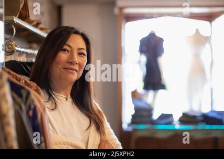 Portrait selbstbewusste weibliche Ladenbesitzerin in der Bekleidungsboutique Stockfoto