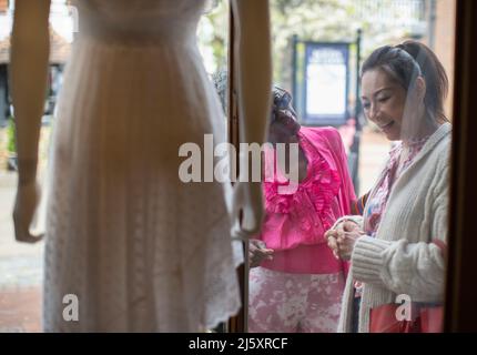 Frauen, Freundinnen, Schaufensterbummel vor der Kleiderboutique Stockfoto