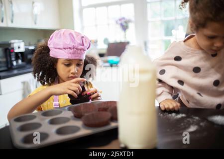 Fokussiertes Mädchen backen Cupcakes in der Küche Stockfoto