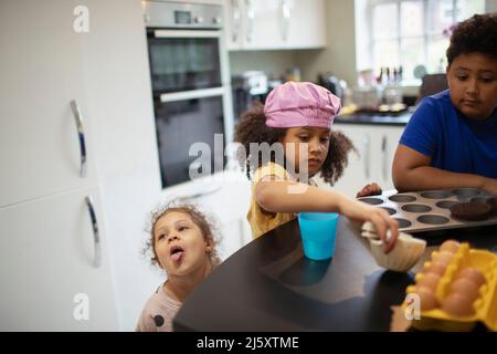 Bruder und Schwestern backen Cupcakes in der Küche Stockfoto