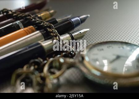 Alte Taschenuhr mit altmodischen Stiften, Konzept- Literatur Stockfoto