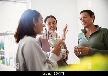 Mutter und junge Erwachsene Töchter unterhalten sich zu Hause Stockfoto