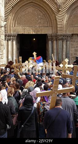 Orthodoxe Christen halten Holzkreuze fest, während sie am 22. April 2022 in Jerusalem, Israel, auf den Eintritt in die Grabeskirche warten. Juden, Christen und Muslime feiern in derselben Woche das diesjährige Passah, Ostern und den Ramadan. Stockfoto