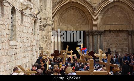 Orthodoxe Christen halten Holzkreuze fest, während sie am 22. April 2022 in Jerusalem, Israel, auf den Eintritt in die Grabeskirche warten. Juden, Christen und Muslime feiern in derselben Woche das diesjährige Passah, Ostern und den Ramadan. Stockfoto