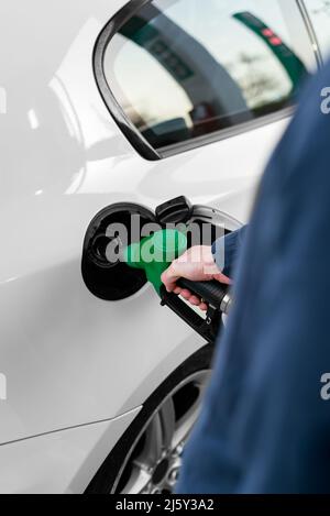 Zugeschnittenes, nicht erkennbarer Mann, der während der Energiekrise den Fahrzeugtank an der Tankstelle auffüllt Stockfoto