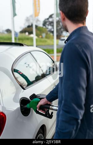 Zugeschnittenes, nicht erkennbarer Mann, der während der Energiekrise den Fahrzeugtank an der Tankstelle auffüllt Stockfoto