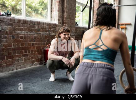 Lächelnde Freundinnen trainieren im Fitnessstudio Stockfoto