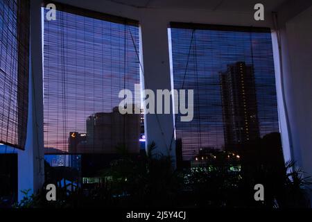 GEORGE TOWN, MALASIA – 30. JANUAR 2020 Sonnenuntergang der Stadt mit einem orangefarbenen Himmel durch Netzvorhänge Stockfoto