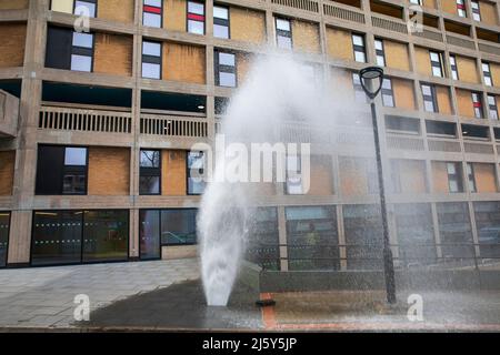 Ein platztes Wasserrohr. Hyde Park Flats, von denen einige noch renoviert werden, Sheffield. Stockfoto