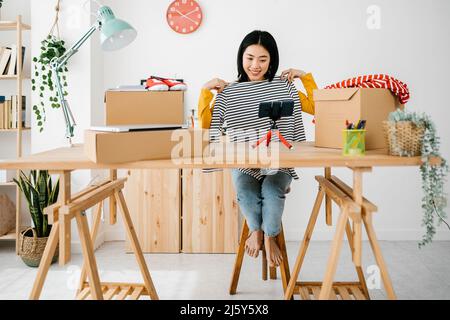 Junge asiatische Frau Blogger Streaming online zeigt neue Kleidung Stockfoto