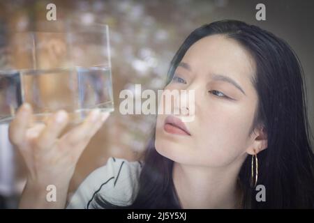 Nahaufnahme einer Designerin, die den Würfel mit Wasser inspiziert Stockfoto