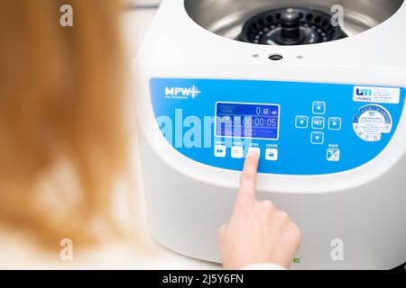 Frau stellt Parameter auf der Zentrifuge für die Probenvorbereitung ein. DNA, onkologische Markeranalyse im klinischen Labor, April 2022, Prag, Tschechische Republik Stockfoto
