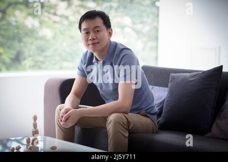 Portrait selbstbewusster Mann, der Holzstücke im Wohnzimmer stapelt Stockfoto