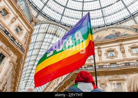 Ein Friedensaktivist hält während einer pazifistischen Demonstration gegen den Faschismus und den Russland-Ukraine-Krieg eine Regenbogenfahne. Friedensflagge in Mailand, Italien Stockfoto