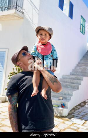 Portrait Vater hält niedlichen, barfuß Kleinkind Sohn auf der Schulter Stockfoto