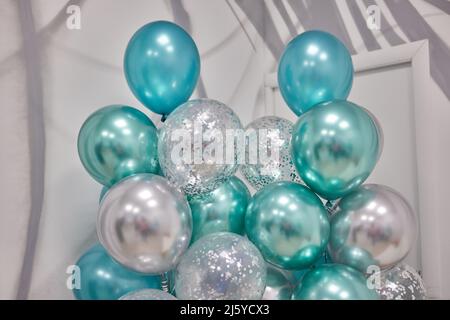 Luftballons auf dunkelblauem Wandhintergrund. Bunte Luftballons im Zimmer für die Geburtstagsfeier vorbereitet Stockfoto