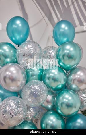 Luftballons auf dunkelblauem Wandhintergrund. Bunte Luftballons im Zimmer für die Geburtstagsfeier vorbereitet Stockfoto