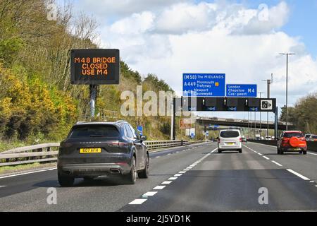 Newport, Wales - 2022. April: Das Auto, das an einem Straßenschild vorbeifährt, das auf die ursprüngliche Severn Bridge hinweist, ist geschlossen, was oft bei starken Winden geschieht Stockfoto