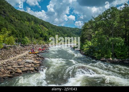 Die Menschen entlang des Ocoee Flusses auf den Felsen, um im Ocoee Wildwasser Zentrum in Tennessee an einem sonnigen Tag im späten Sommer Kajak zu fahren und zu flossen Stockfoto