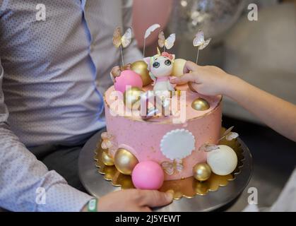 kendi Bar zum Kindergeburtstag. Kuchen mit Einhorn und Süßigkeiten, Ornamente in sanften Pastelltönen Stockfoto
