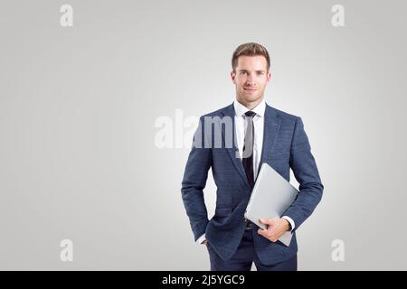 Junger Geschäftsmann mit einem Laptop auf neutralem Hintergrund Stockfoto