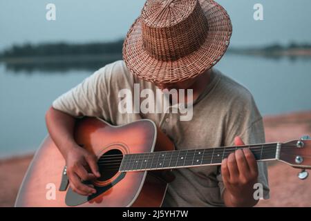 Junge Künstler freuen sich, Gitarre zu spielen Stockfoto