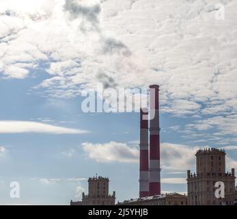 CHP in der Stadt. Rauch steigt aus den Wärmerohren in den Himmel Stockfoto