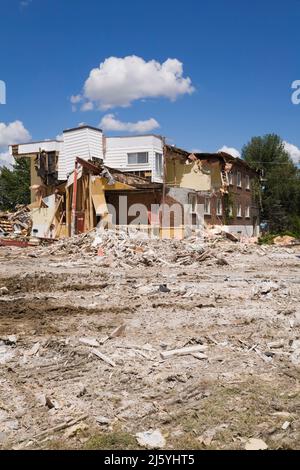 Teilweise abgerissene Wohngebäude und Grundstück mit verschiedenen Trümmern. Stockfoto