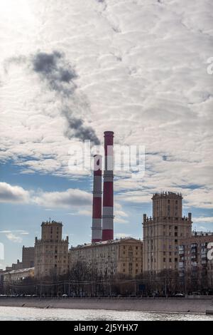 CHP in der Stadt. Rauch steigt aus den Wärmerohren in den Himmel Stockfoto