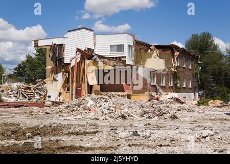 Teilweise abgerissene Wohngebäude und Grundstück mit verschiedenen Trümmern. Stockfoto