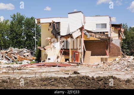 Teilweise abgerissene Wohngebäude und Grundstück mit verschiedenen Trümmern. Stockfoto