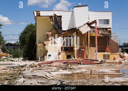 Teilweise abgerissene Wohngebäude und Grundstück mit verschiedenen Trümmern. Stockfoto