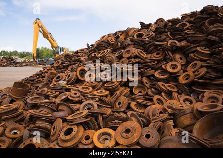 Verschiedene weggeworfene rostige Stahlscheiben- und Trommelbremsen auf dem Altmetall-Recyclinghof. Stockfoto