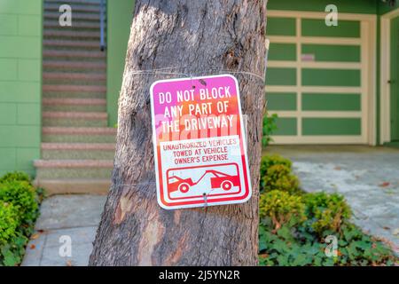 Blockieren Sie nicht die Hinweisschilder für die Auffahrt auf einem Baumstamm in San Francisco, Kalifornien Stockfoto