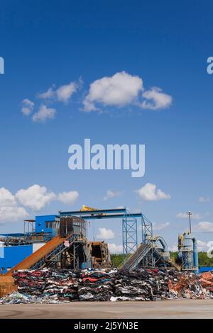 Gestapelte und zerkleinerte Automobile und industrielle Metallzerkleinerer auf einem Altmetall-Recyclinghof. Stockfoto