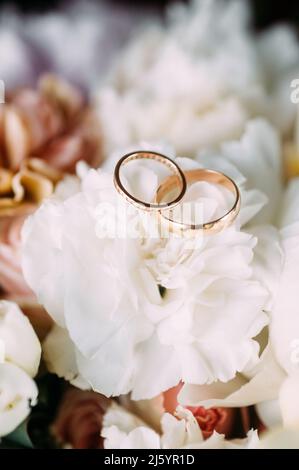 Hochzeit Goldringe auf weißen Blumen Nahaufnahme Stockfoto