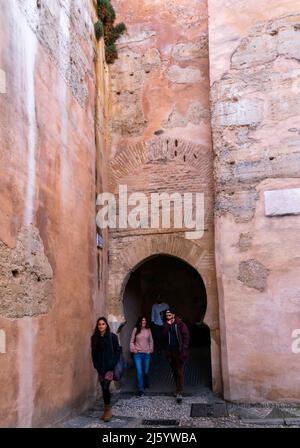 Touristen spazieren durch die mittelalterliche Mauer aus dem 11. Jahrhundert und gehen in der Nähe von pl Larga, Granada, Spanien Stockfoto