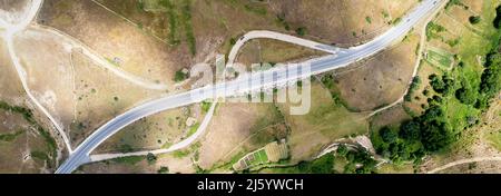 Direkt über der horizontalen Luftlandstraße, umgeben von Land und Wiesen der Landschaft an sonnigen Tagen. Spanien Stockfoto