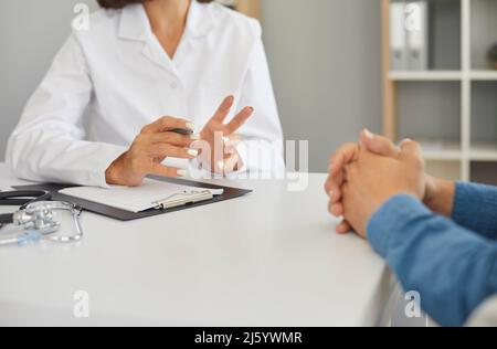 Arzt in der Klinik, der den Patienten konsultiert und ihm über seine Behandlung erzählt Stockfoto