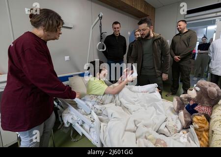 Der ukrainische Präsident Wolodymyr Zelensky besuchte das nationale Kinderkrankenhaus Okhmatdyt. Er besuchte zwei Waisenkinder aus Mariupol, die von den russischen Besatzern aus der Stadt geholt wurden, aber die ukrainischen Behörden schafften es, sie zurückzugeben, jetzt werden sie von ihren Verwandten betreut. Als Folge der aktiven Feindseligkeiten in Mariupol verloren Ilja Matvienko und Kira Obedinska ihre Eltern. Die Kinder erlitten Verletzungen unterschiedlicher Schwere. Die Besatzer brachten sie in das Gebiet, das nicht von der Ukraine kontrolliert wurde. Zelensky traf sich auch mit den Ärzten von Okhmatdyt und überreichte ihnen staatliche Auszeichnungen. Stockfoto