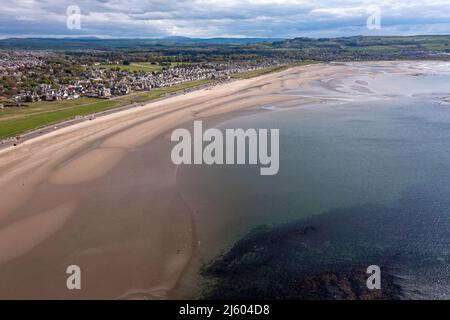 Ayr, Schottland, Großbritannien. 26. April 2022. IM BILD: Luftdrohnenansicht von oben auf den Ayr Beach mit Blick auf den Firth of Clyde und die Küstenstadt Ayr. Westlich von Schottland sah man strahlenden Sonnenschein und blauen Himmel an der Küste am Ayr Beach. Menschen gehen spazieren und ein Reiter nimmt ihr Pferd durch einen Galopp im kühlen Meerwasser. Quelle: Colin Fisher/Alamy Live News Stockfoto