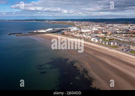 Ayr, Schottland, Großbritannien. 26. April 2022. IM BILD: Luftdrohnenansicht von oben auf den Ayr Beach mit Blick auf den Firth of Clyde und die Küstenstadt Ayr. Westlich von Schottland sah man strahlenden Sonnenschein und blauen Himmel an der Küste am Ayr Beach. Menschen gehen spazieren und ein Reiter nimmt ihr Pferd durch einen Galopp im kühlen Meerwasser. Quelle: Colin Fisher/Alamy Live News Stockfoto