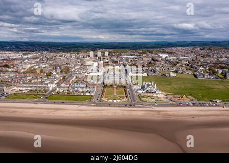 Ayr, Schottland, Großbritannien. 26. April 2022. IM BILD: Luftdrohnenansicht von oben auf den Ayr Beach mit Blick auf den Firth of Clyde und die Küstenstadt Ayr. Westlich von Schottland sah man strahlenden Sonnenschein und blauen Himmel an der Küste am Ayr Beach. Menschen gehen spazieren und ein Reiter nimmt ihr Pferd durch einen Galopp im kühlen Meerwasser. Quelle: Colin Fisher/Alamy Live News Stockfoto