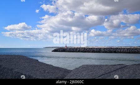 Kleiner rot-weißer Leuchtturm (Farol da Meia Praia) am Ende der Alvor-Promenade, Leuchtfeuer für Boote, die zur Odiaxere-Flussmündung, Algarve, S, fahren Stockfoto