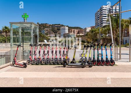 Parkplatz für Elektroroller, an der Strandpromenade des Hafens von Malaga. Link, Dott, VOI Motorroller zur Miete auf der Promenade 'Muelle Uno'. Stockfoto