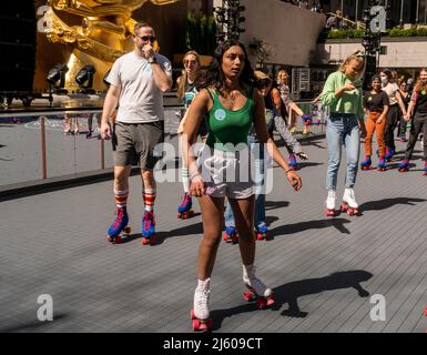 New Yorker und Touristen skaten am großen Eröffnungstag, Freitag, den 15. April 2022, um Flipper’s Roller Boogie Palace im Rockefeller Center in New York. Das Rockefeller Center hat die legendäre Rollschuhbahn Flipper’s in Los Angeles nachgebaut, die 1981 geschlossen wurde, indem sie ihre legendäre Eislaufbahn durch eine Rollbahn ersetzt hat. Das Rockefeller Center hatte zuletzt 1940 eine Rollschuhbahn. (© Richard B. Levine) Stockfoto