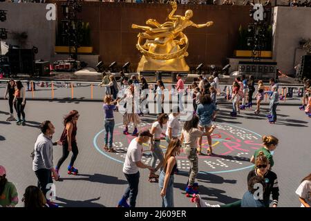 New Yorker und Touristen skaten am großen Eröffnungstag, Freitag, den 15. April 2022, um Flipper’s Roller Boogie Palace im Rockefeller Center in New York. Das Rockefeller Center hat die legendäre Rollschuhbahn Flipper’s in Los Angeles nachgebaut, die 1981 geschlossen wurde, indem sie ihre legendäre Eislaufbahn durch eine Rollbahn ersetzt hat. Das Rockefeller Center hatte zuletzt 1940 eine Rollschuhbahn. (© Richard B. Levine) Stockfoto