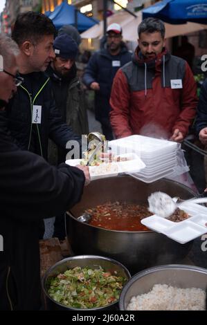 26. April 2022, Hessen, Frankfurt/Main: Mitarbeiter geben im Bahnhofsviertel während der Fastenbrechung 5. Essen aus, die von der Initiative gemeinsam Fastenbrechen organisiert wurde. Im Bereich der Elbestraße zwischen Münchenerstraße und Kaiserstraße laden einheimische Geschäftsleute und Restaurants zum gemeinsamen Essen ein. Der islamische Fastenmonat Ramadan dauert bis zum Abend des 1. Mai 2022 an. Foto: Sebastian Gollnow/dpa Stockfoto