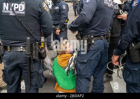 Umweltaktivisten, die mit Extinction Rebellion in Verbindung stehen, leisten zivilen Ungehorsam, indem sie am Samstag, dem 23. April 2022, den Verkehr auf der Sixth Avenue in New York blockieren. Der Protest lenkte die Aufmerksamkeit auf die Untätigkeit der Regierung, die Klimakatastrophe zu stoppen, und die Demonstranten wurden daraufhin verhaftet (© Richard B. Levine) Stockfoto